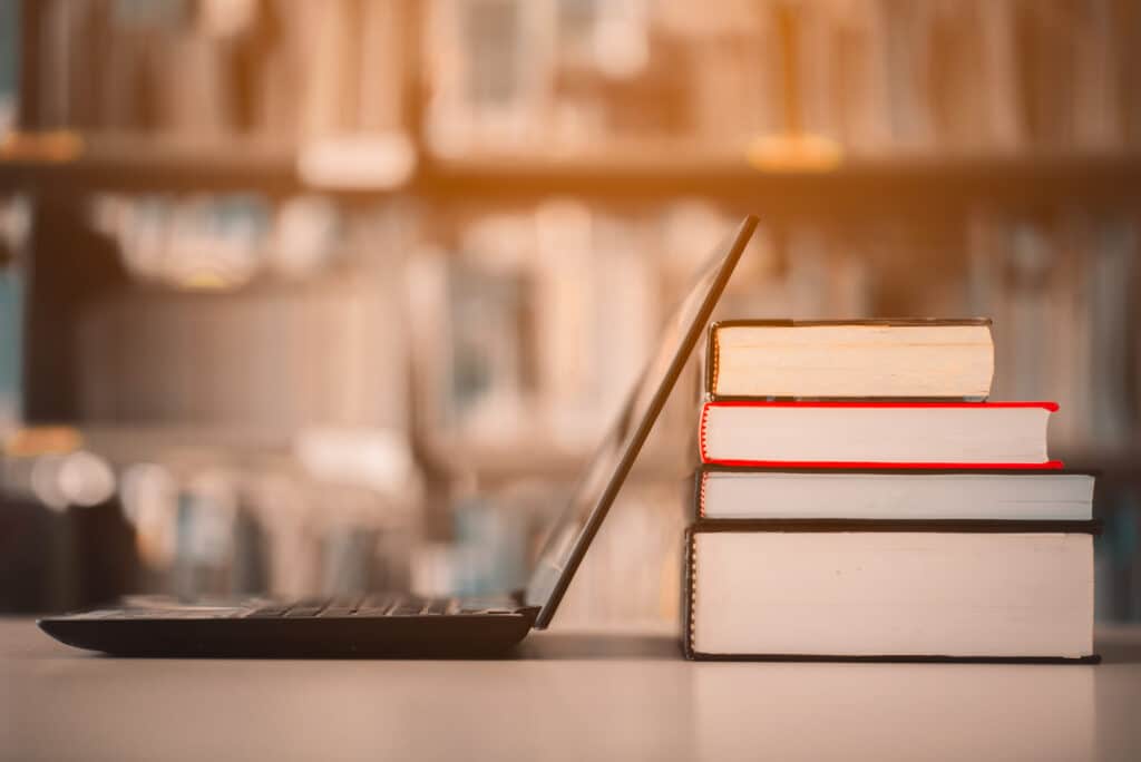 Bookshelves and laptops are placed on the library desk.