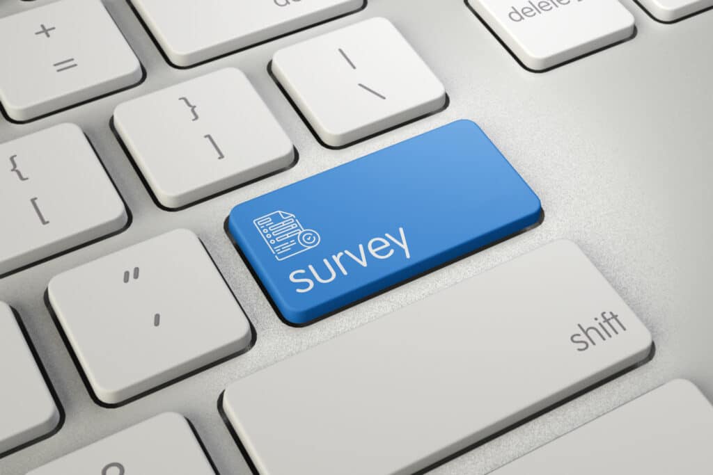 High quality render of a modern computer keyboard detail with blue survey text on it.